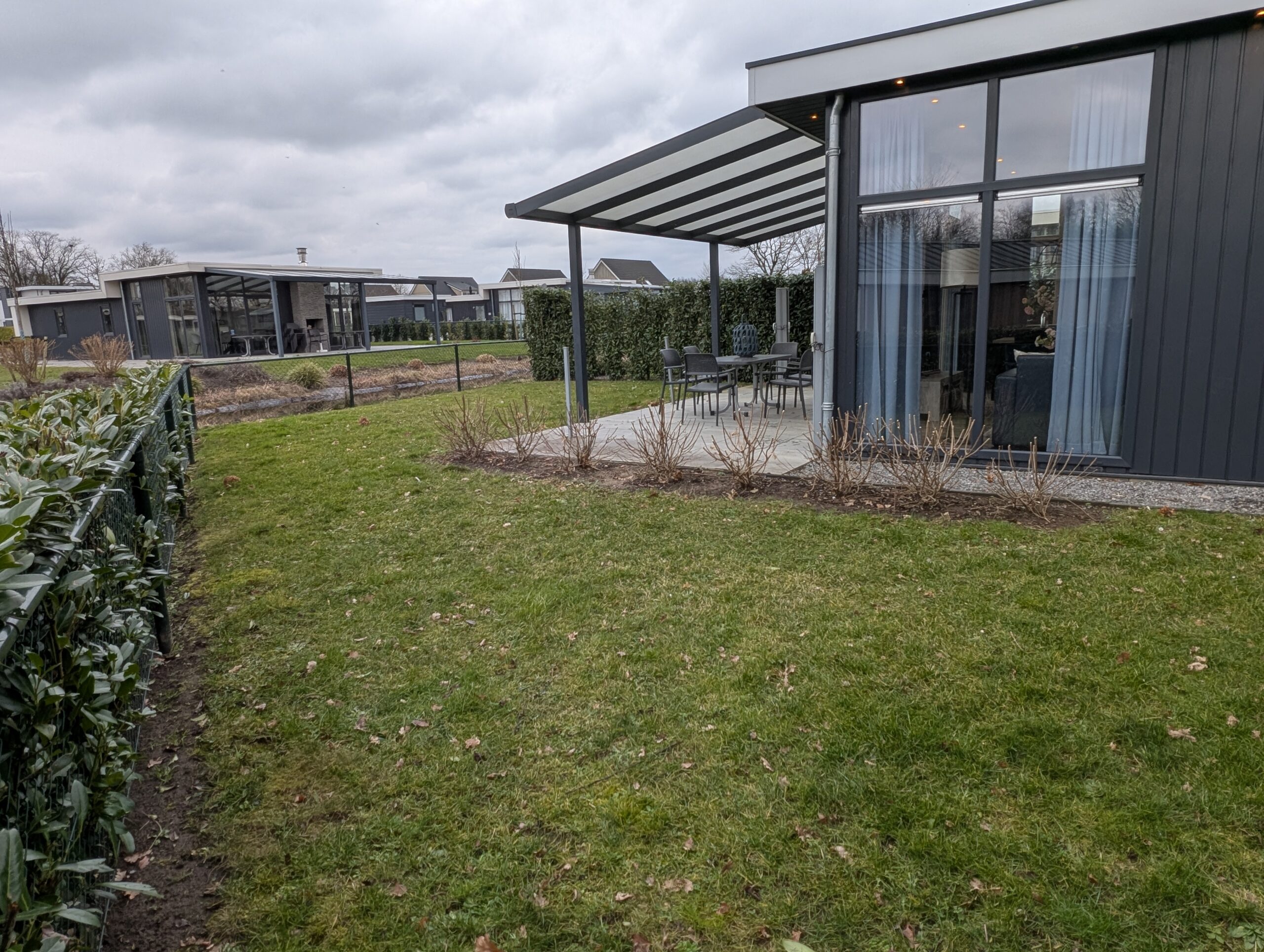 Een foto van de gehele achtertuin met het water erachter