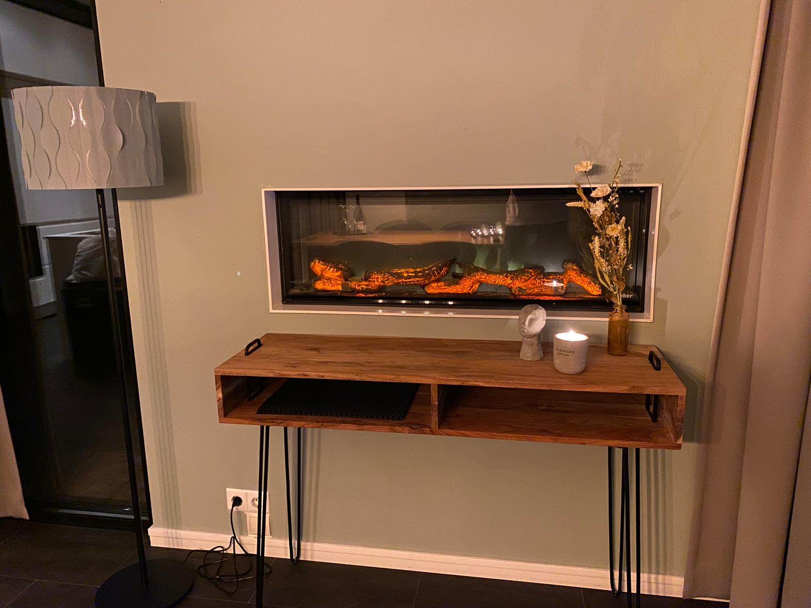 Een muur van de recreatiewoning met een haard erin